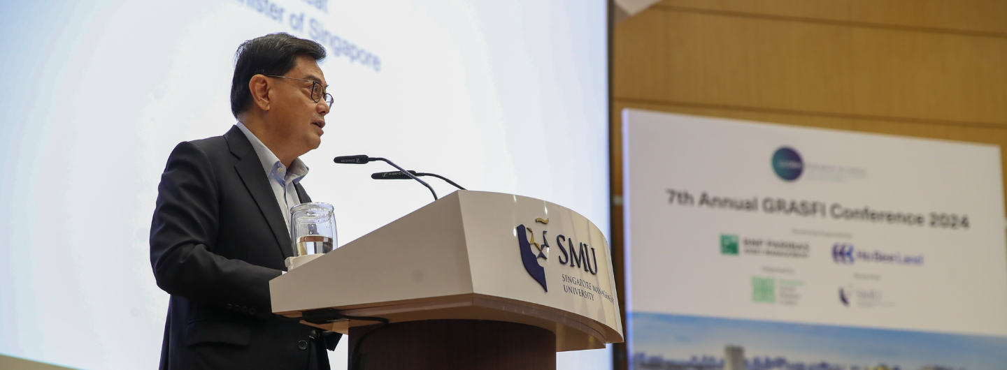 Man at podium with SMU logo giving a speech; "7th Annual GRASFI Conference 2024" displayed.